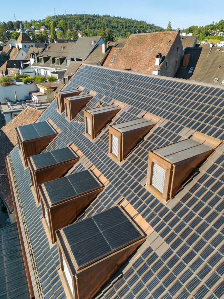 Auf den handelsüblichen Tondachziegeln sind kleine Photovoltaikmodule befestigt. So lassen sich Energieproduktion und Ortsbildschutz in Einklang bringen. (Foto: Gasser Ceramic/pd)